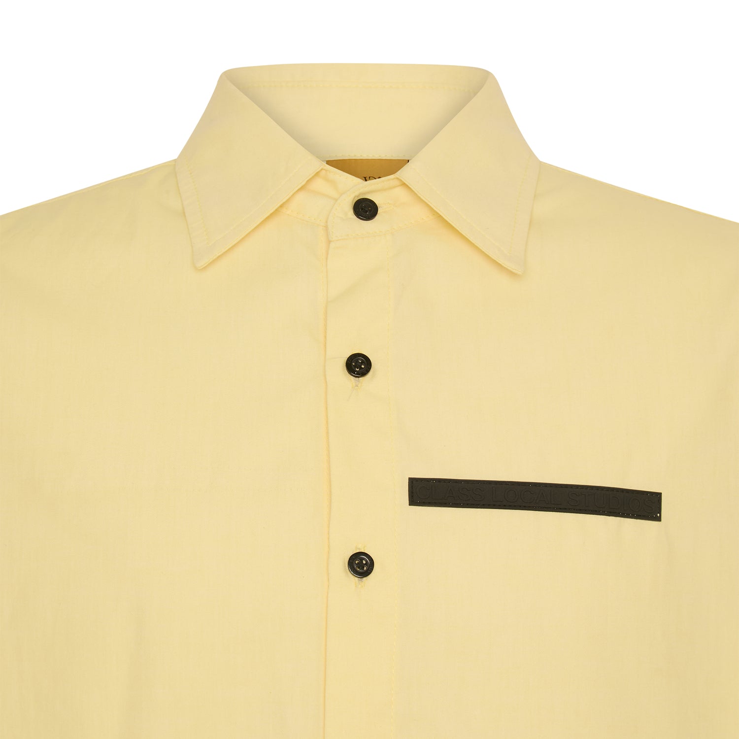Camisa amarela com gola e botões pretos; faixa preta no bolso do peito