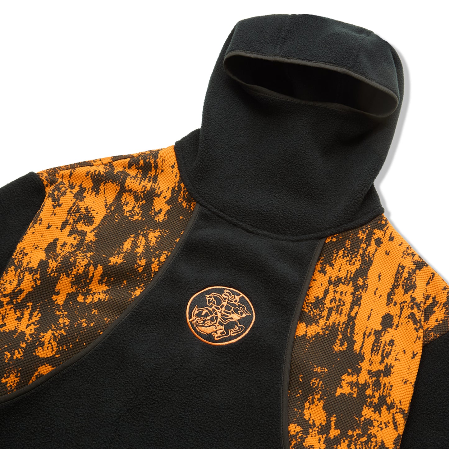 Fleece preta com capuz e emblema dourado na frente sobre painel laranja salpicado