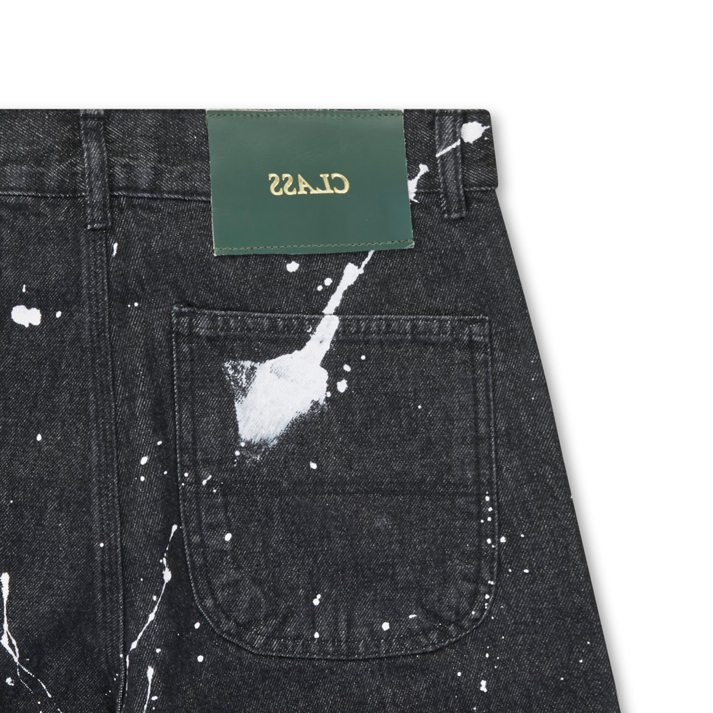 Jeans preto com bolso frontal e respingos brancos, etiqueta verde no cós.