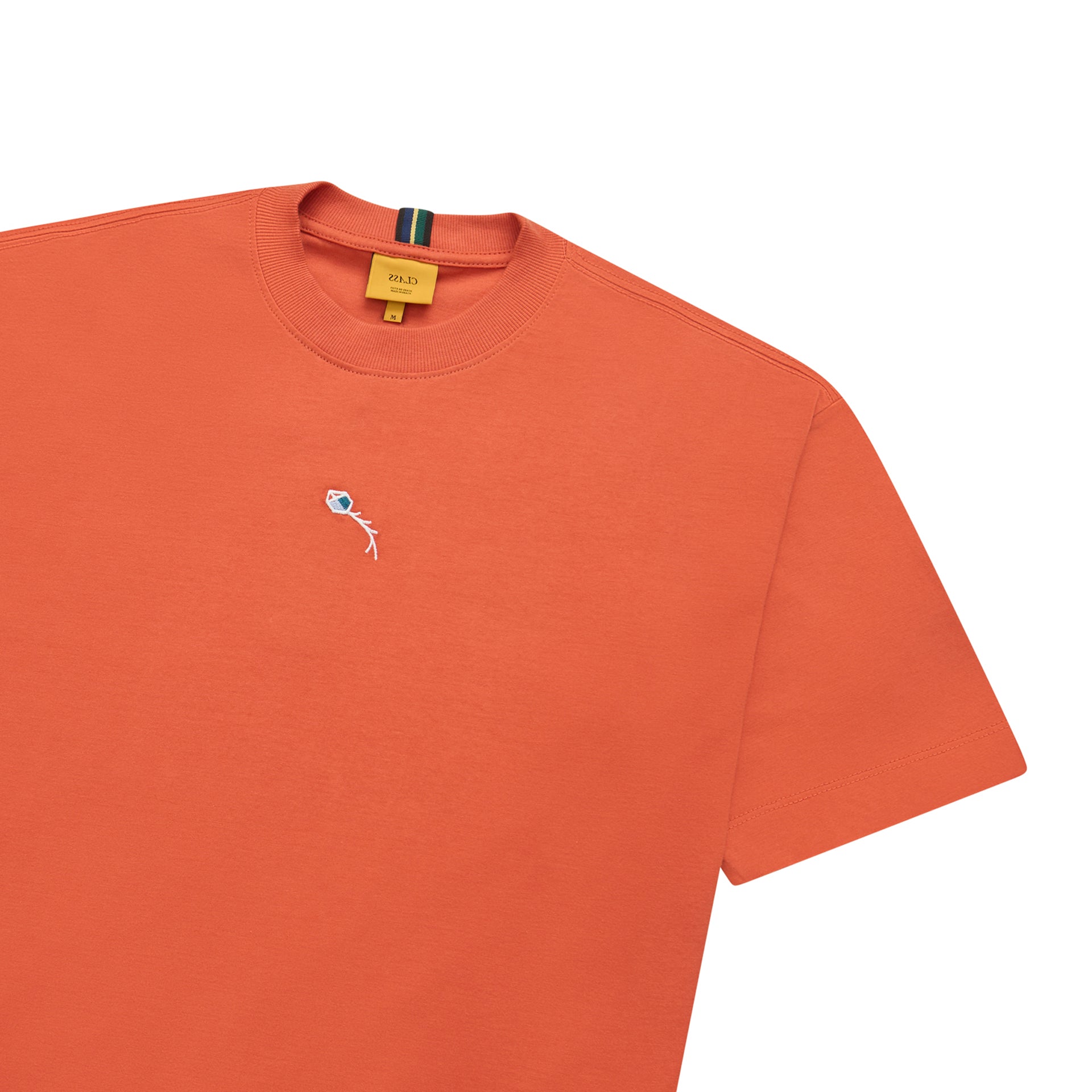 Camiseta laranja com gola canelada e etiqueta interna; estampa pequena no peito