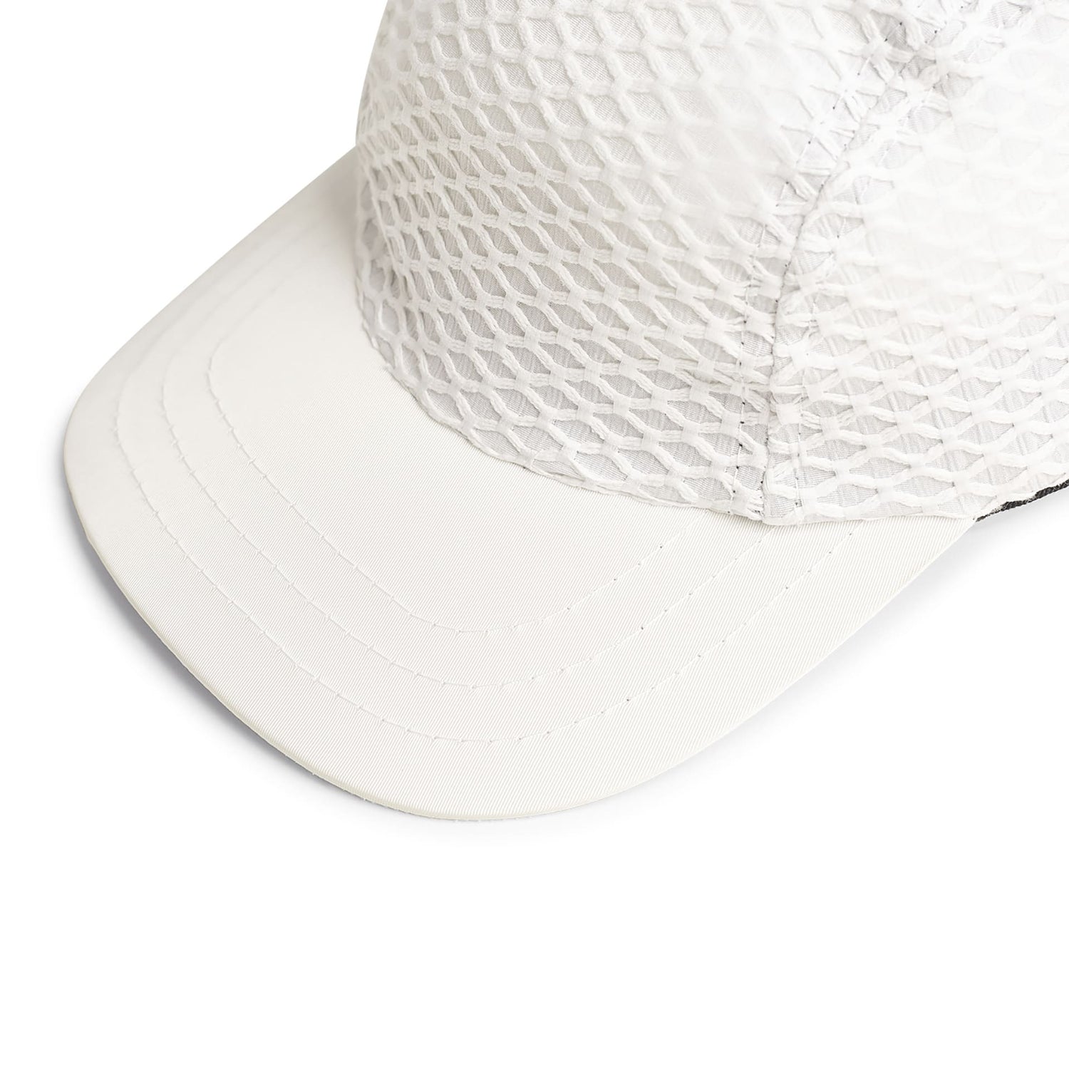 Boné três painéis off-white em malha texturizada, aba curva e costuras laterais.