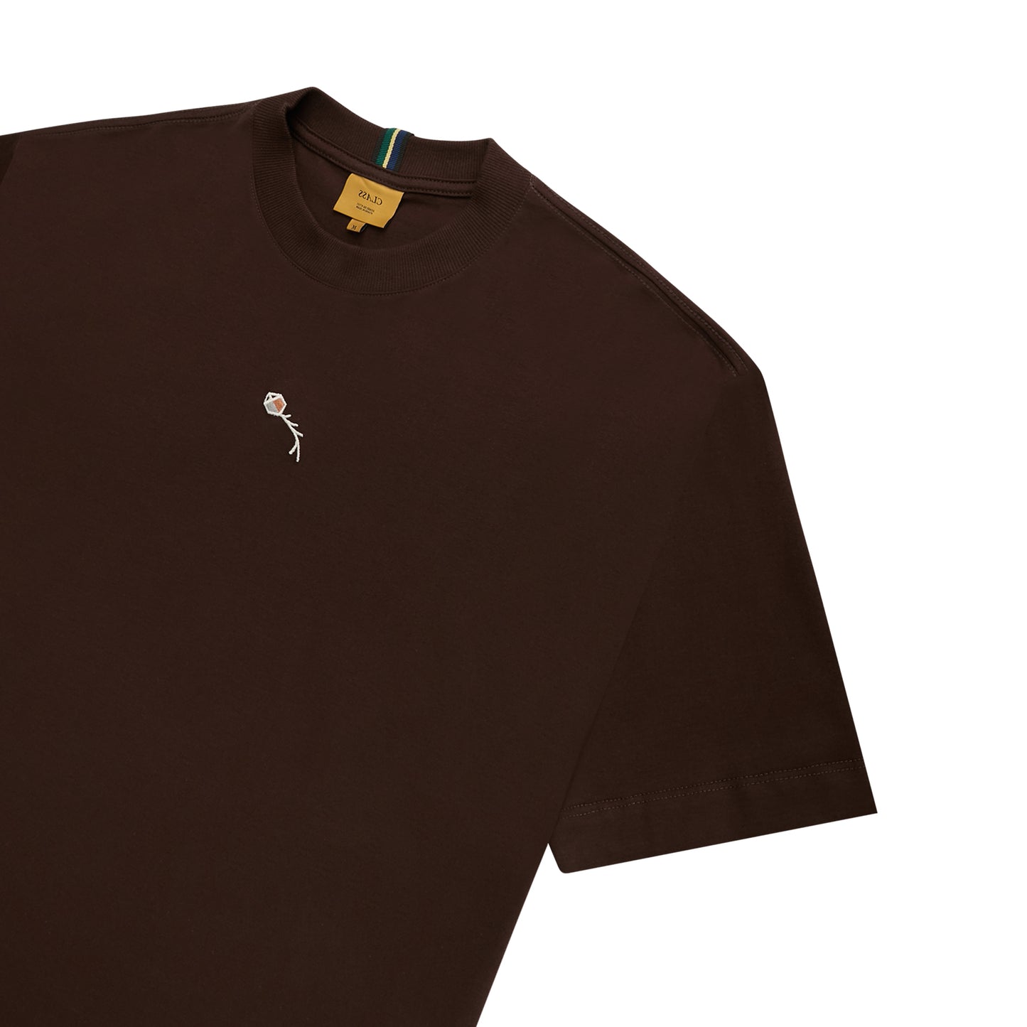 Camiseta marrom com mini ilustração branca no peito e etiqueta interna