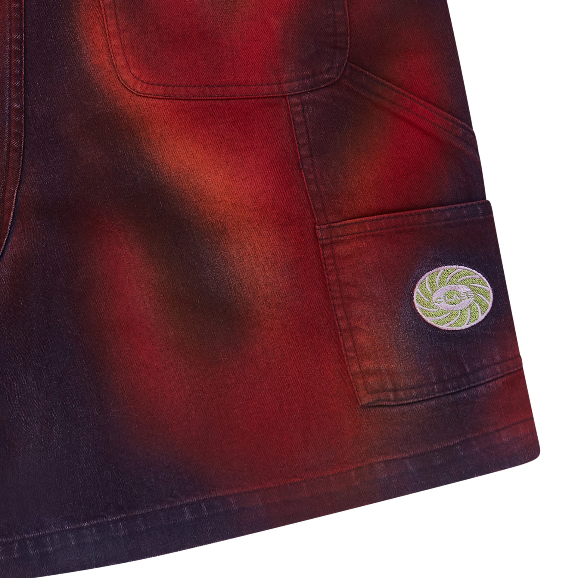 Barra do shorts jeans carpenter com bolso cargo e etiqueta circular; estampa vermelha